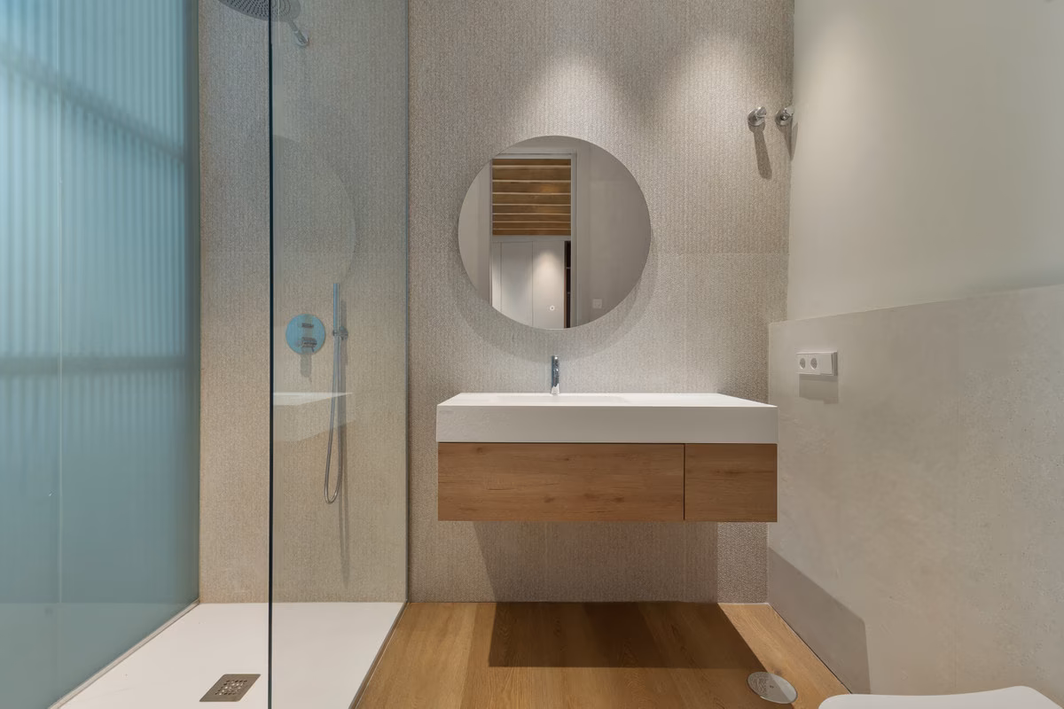Bad mit bodengleicher Dusche und rundem Spiegel