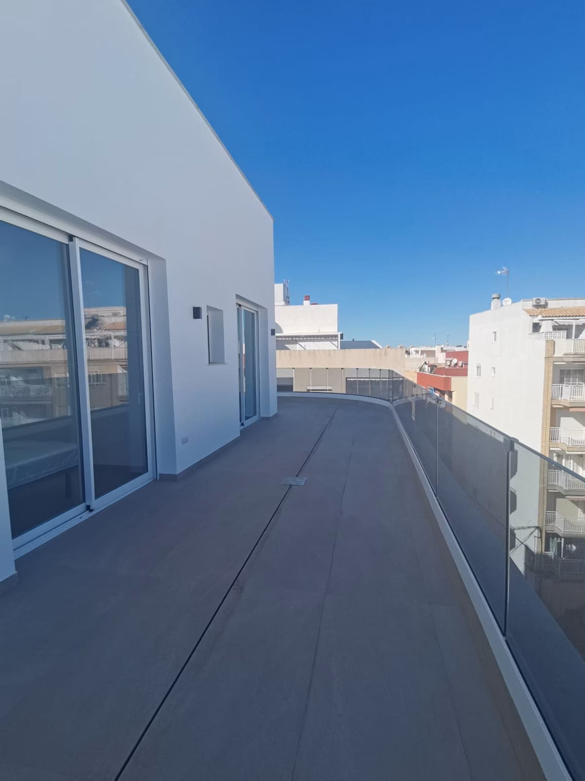 Terrasse entlang des Penthouses mit gläsernen Schiebetüren