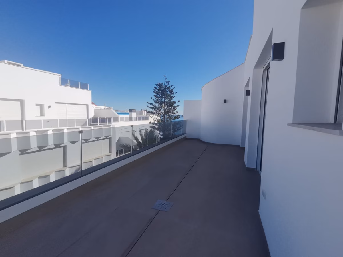 Penthouse-Terrasse mit Glasgeländer und Blick über die Nachbardächer