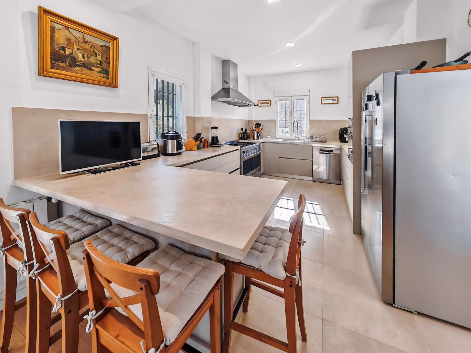 Kitchen with a breakfast bar, stools and stainless-steel appliances