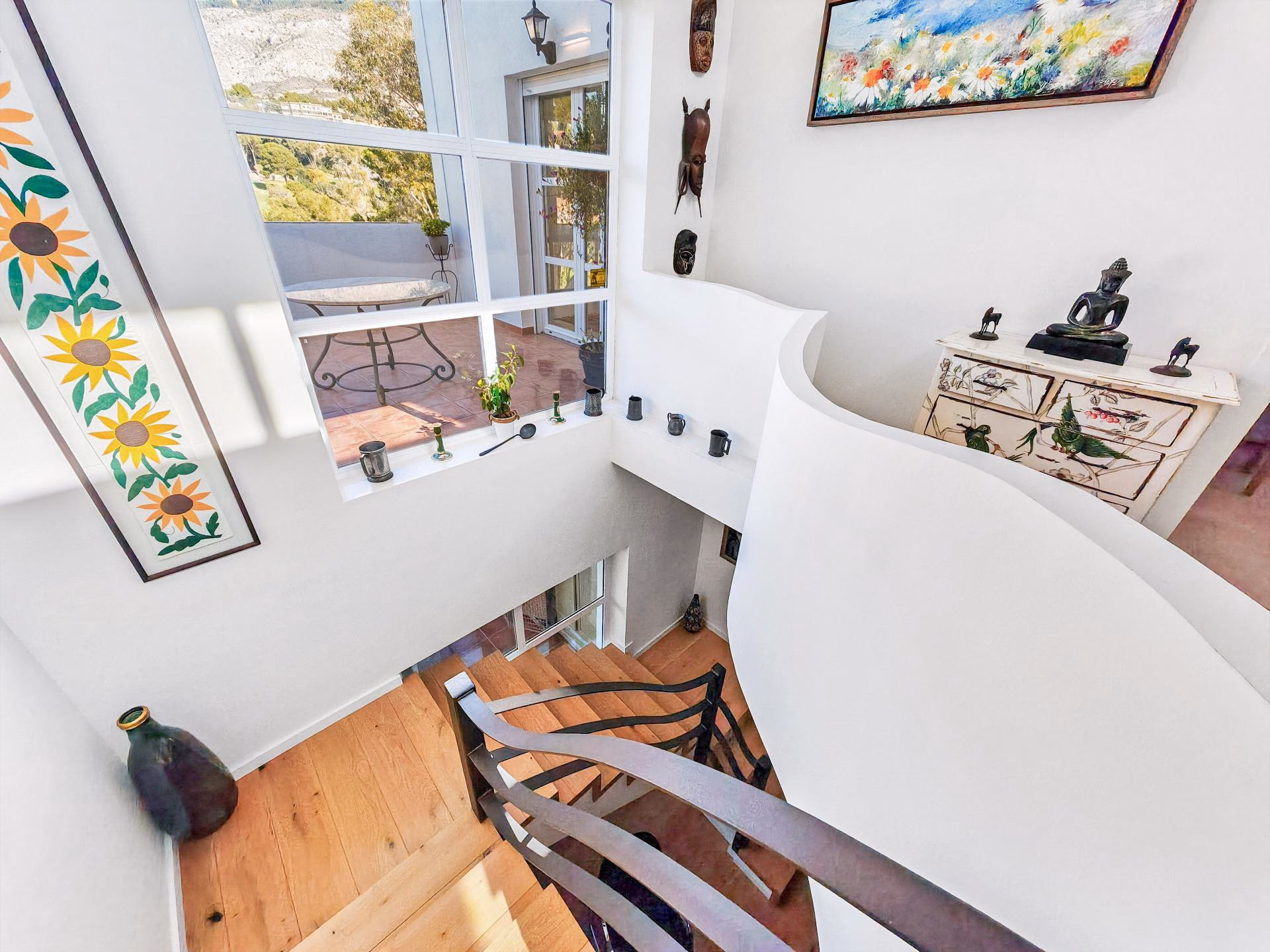 Staircase with wooden handrail and a window over the garden