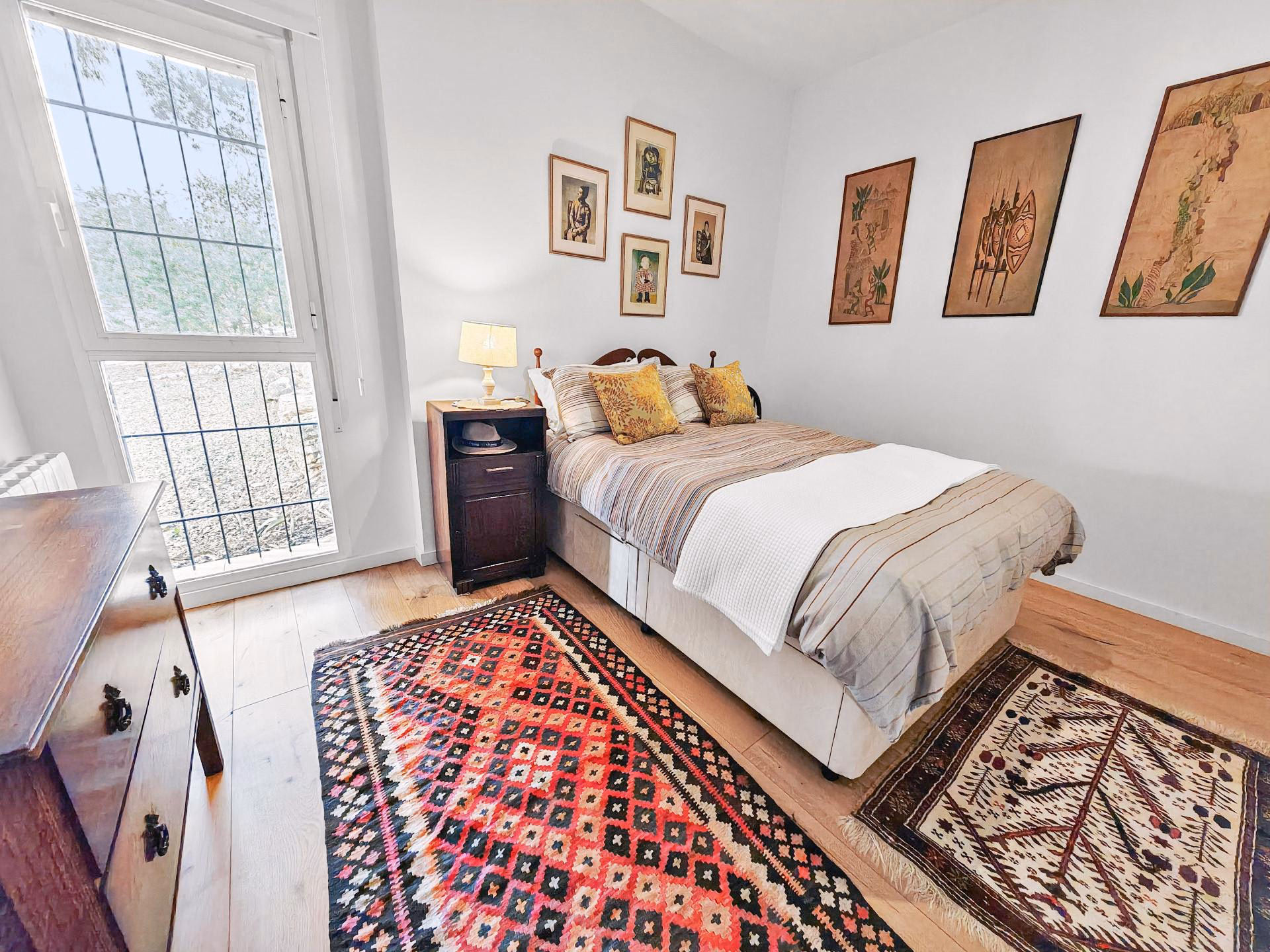Bedroom with a double bed, rugs and a glazed door to the terrace