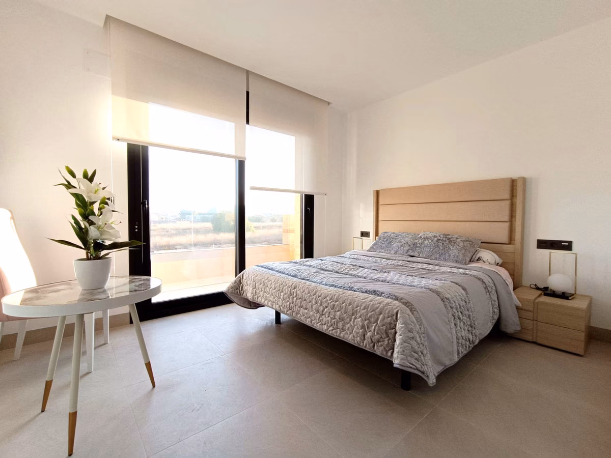 Dormitorio con grandes ventanales y cabecero tapizado