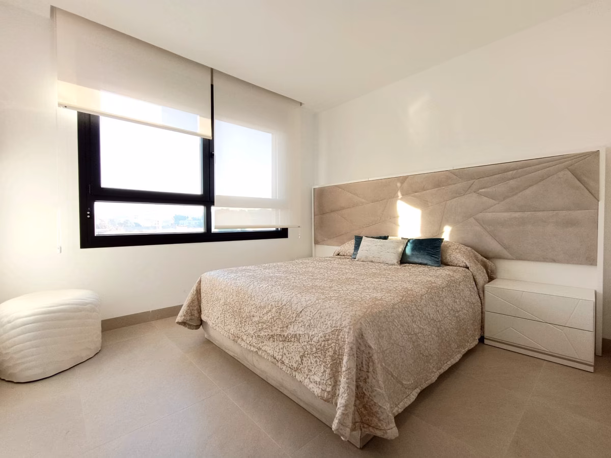 Dormitorio con ventana panorámica y cabecero acolchado