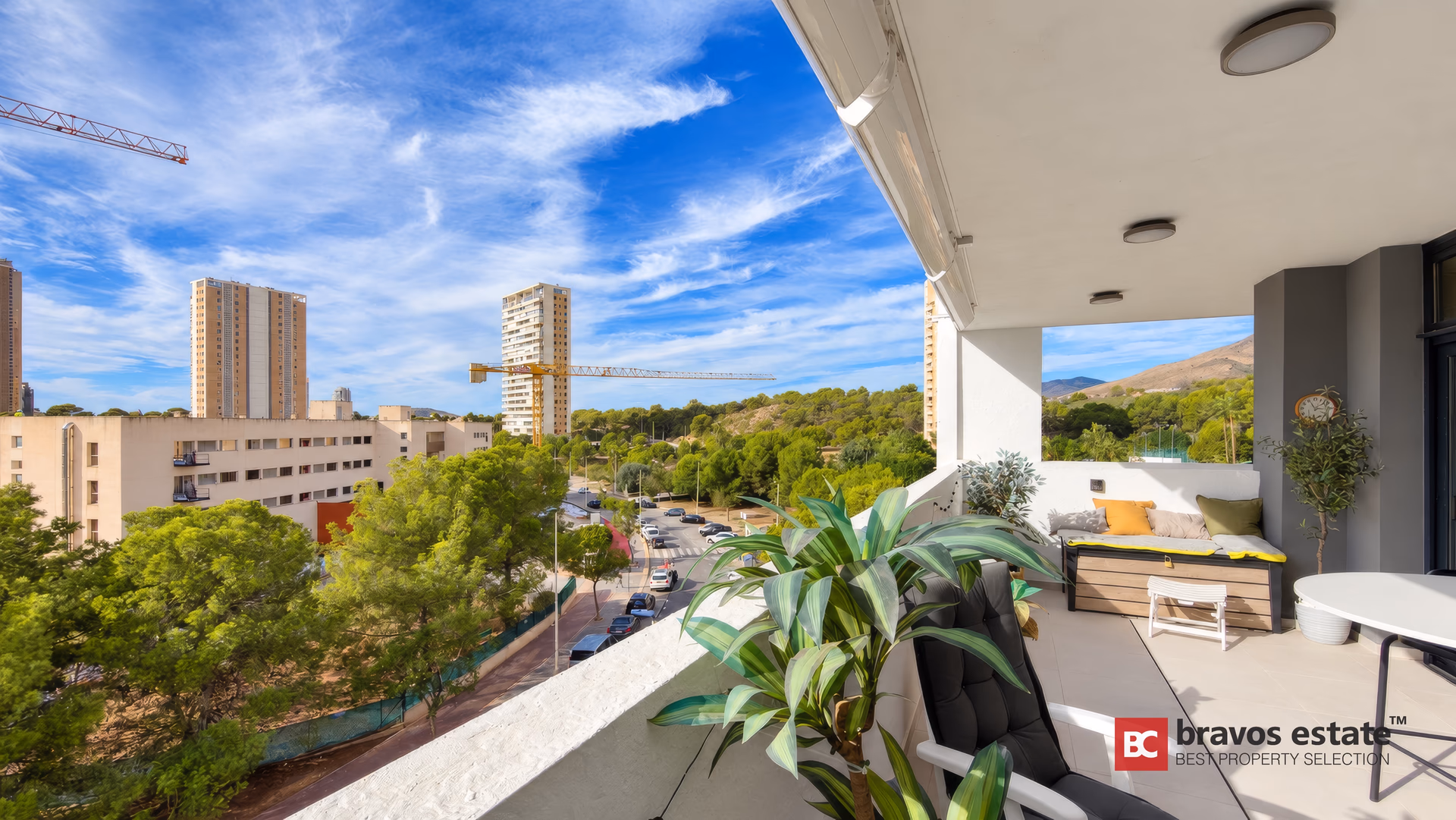 Angle de la terrasse avec plantes en pot, la verdure du golf et les collines au loin