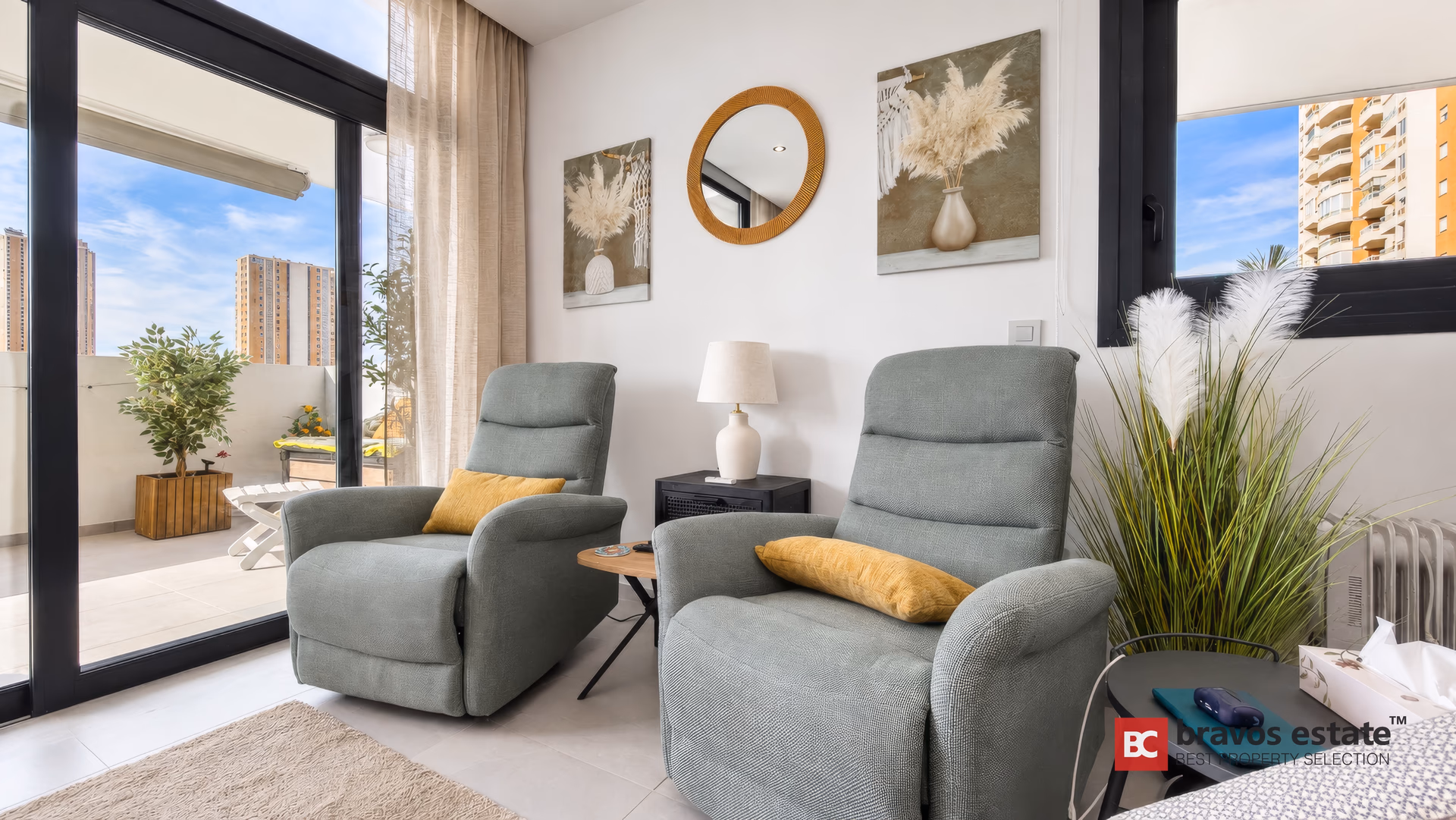 Deux fauteuils relax près des baies de la terrasse, avec table d'appoint et lampe