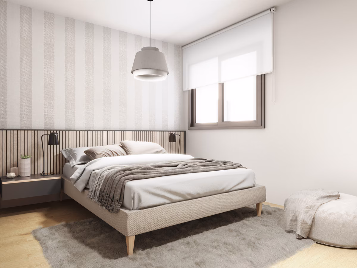 Chambre double avec tête de lit capitonnée et mur à rayures