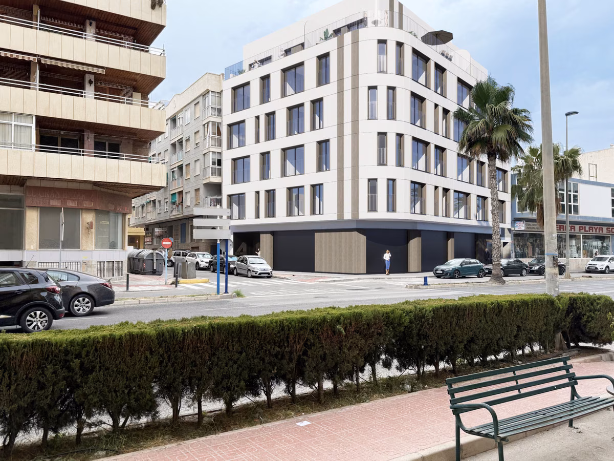 Immeuble d’angle blanc d’Edificio Anamar dans une rue bordée de palmiers au centre de Torrevieja