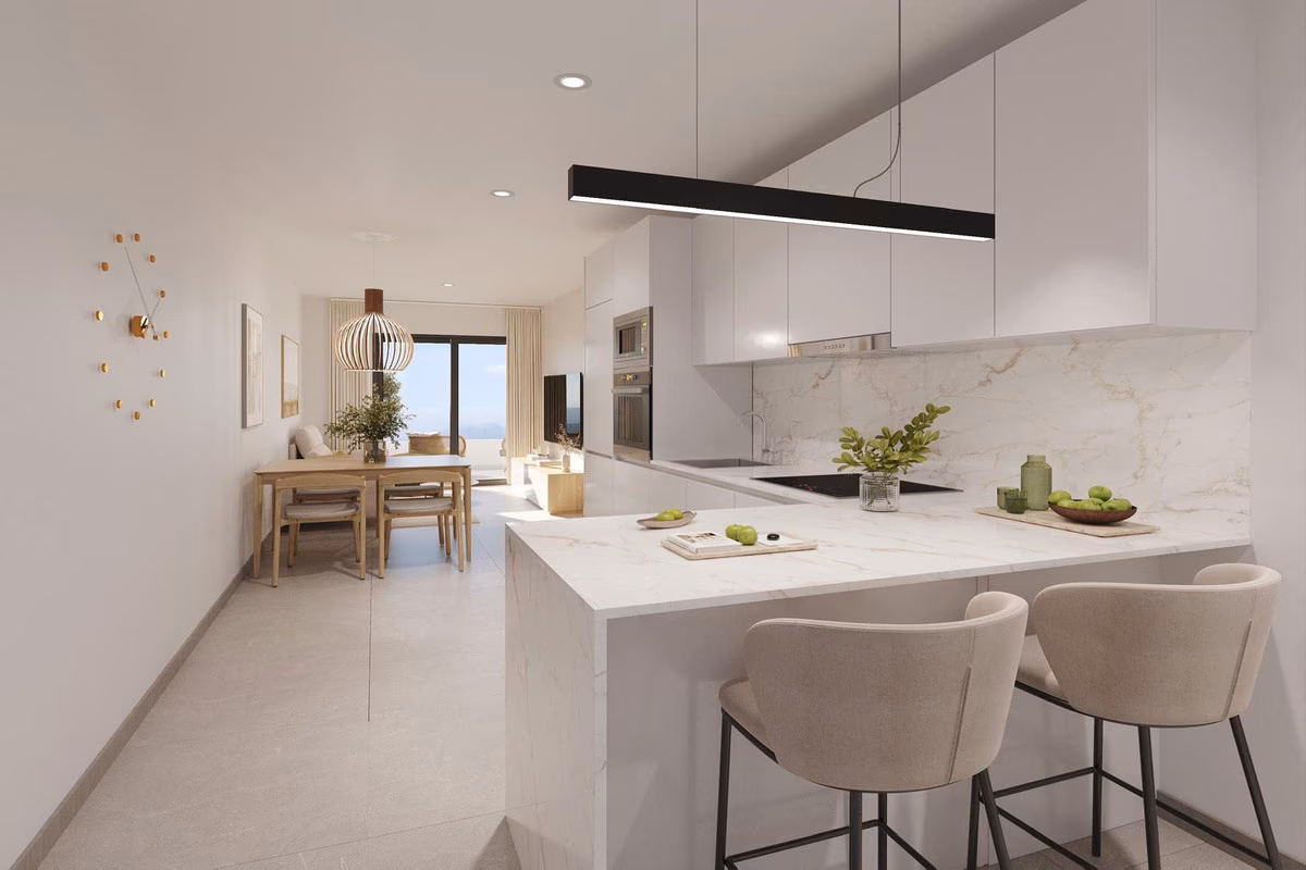 Barra de cocina con taburetes y el comedor detrás