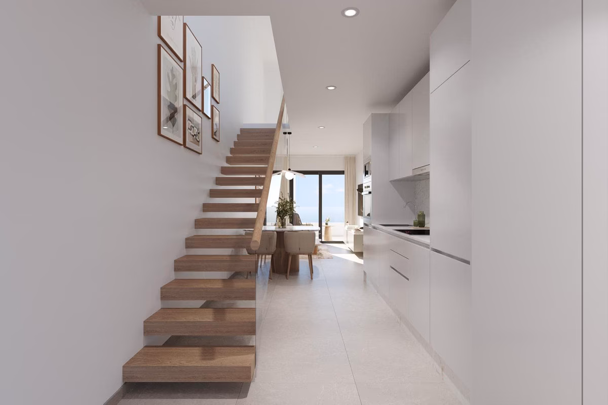 Escalera abierta de madera junto a la cocina en un dúplex