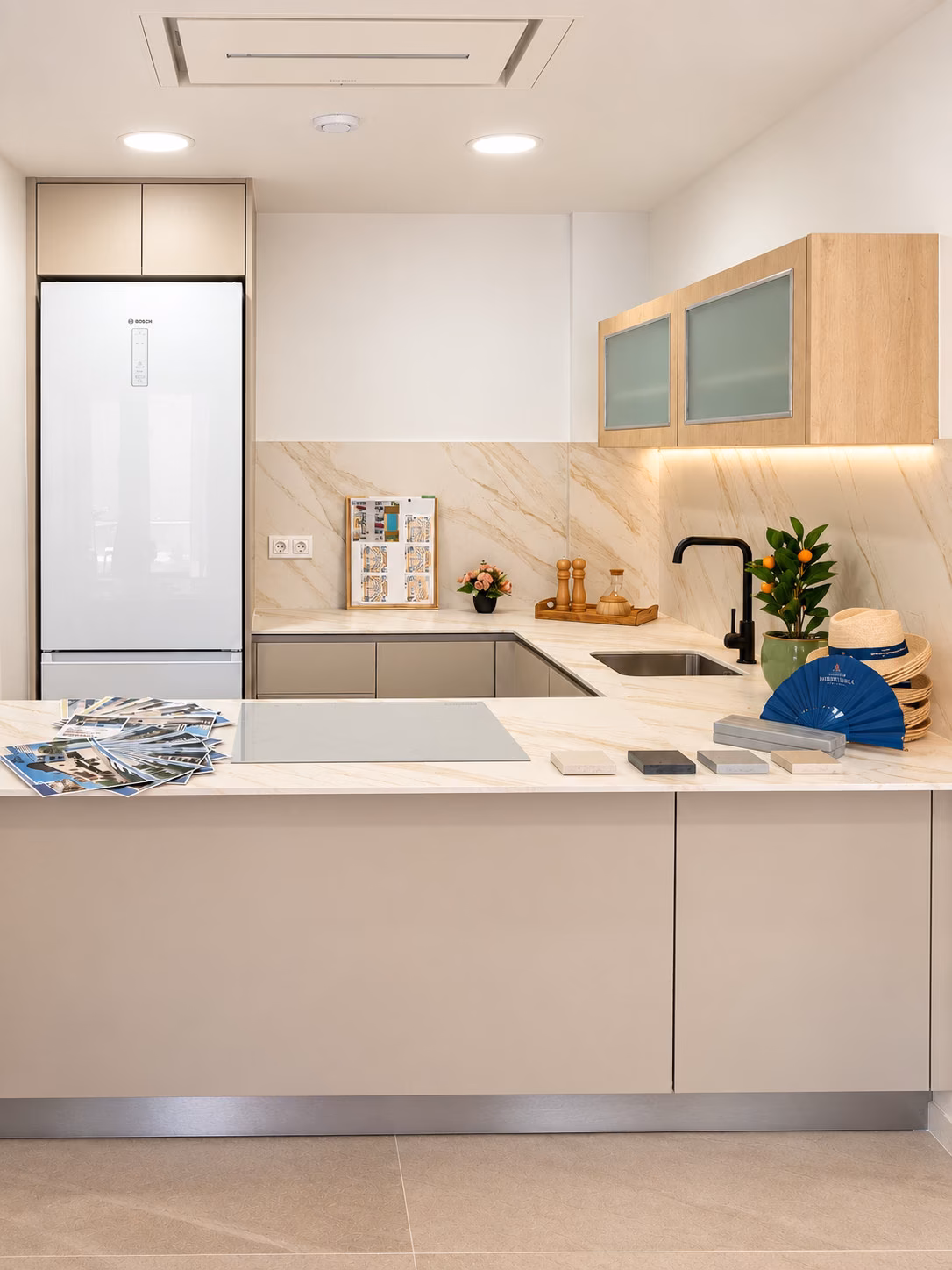 Cuisine équipée avec colonne réfrigérateur dans un appartement témoin meublé