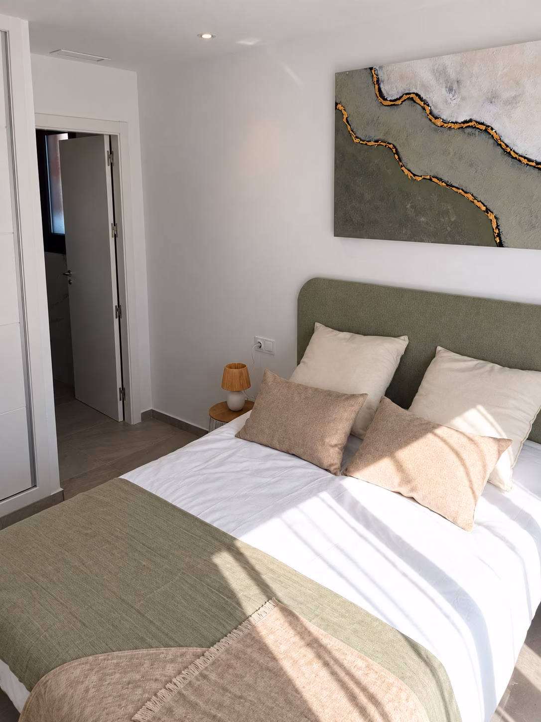 Chambre double avec tête de lit verte dans un appartement témoin meublé
