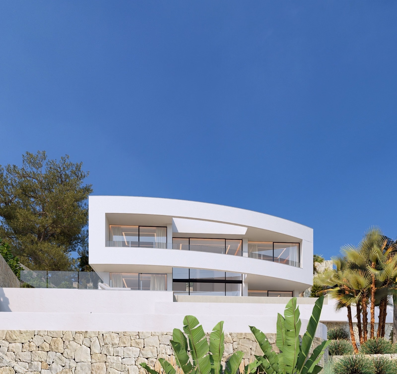 Villa above a stone retaining wall, with planting and the garage entrance