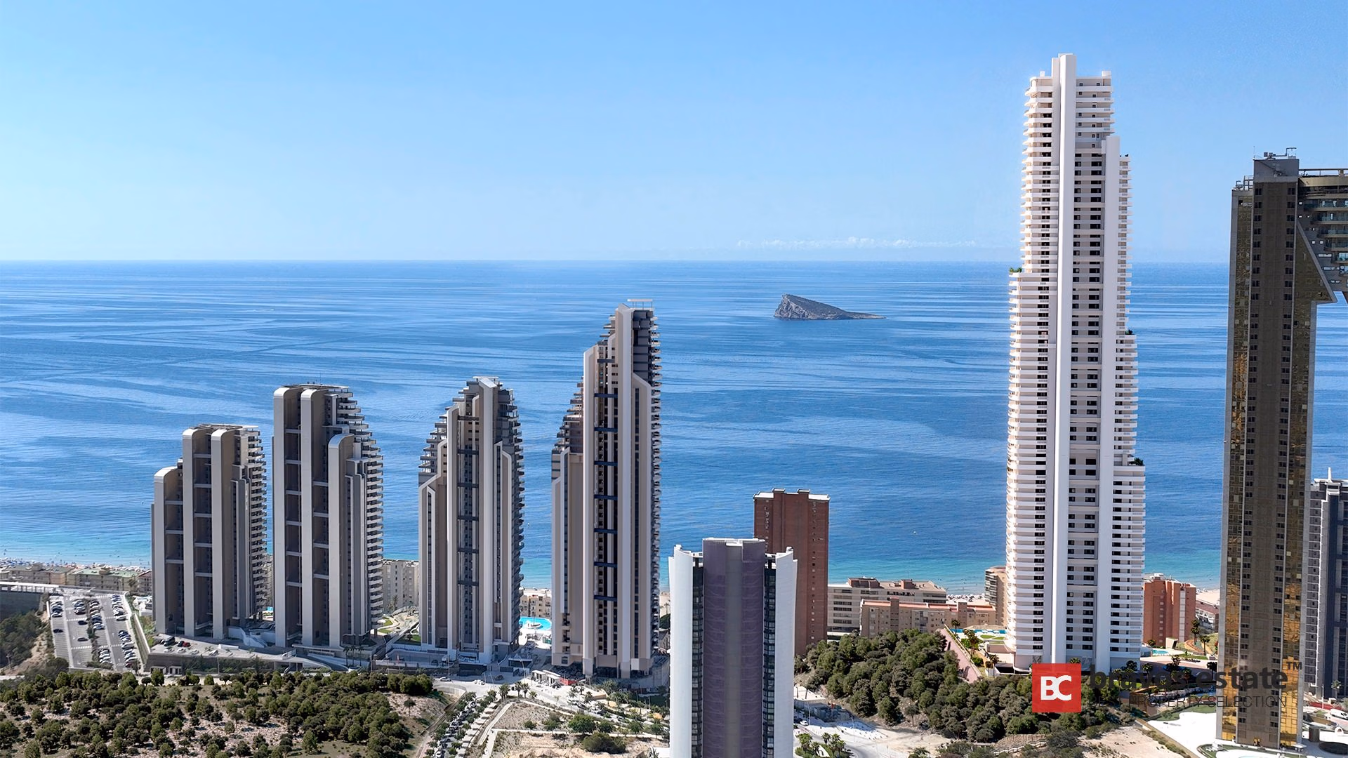 Aerial view of TM Tower's slim white high-rise rising above Playa de Poniente coastline with Benidorm island backdrop