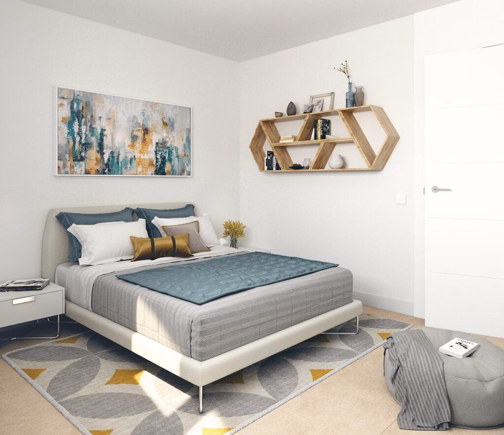 Schlafzimmer mit Doppelbett, grauer Tagesdecke und sechseckigem Wandregal