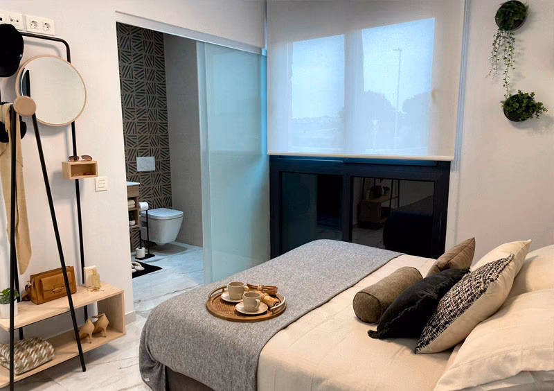 Bedroom with glass-partitioned en-suite bathroom in the La Hoya show apartment