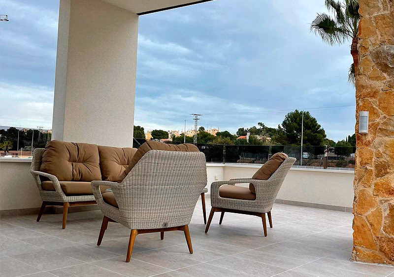Covered terrace with rattan armchairs in the La Hoya show apartment