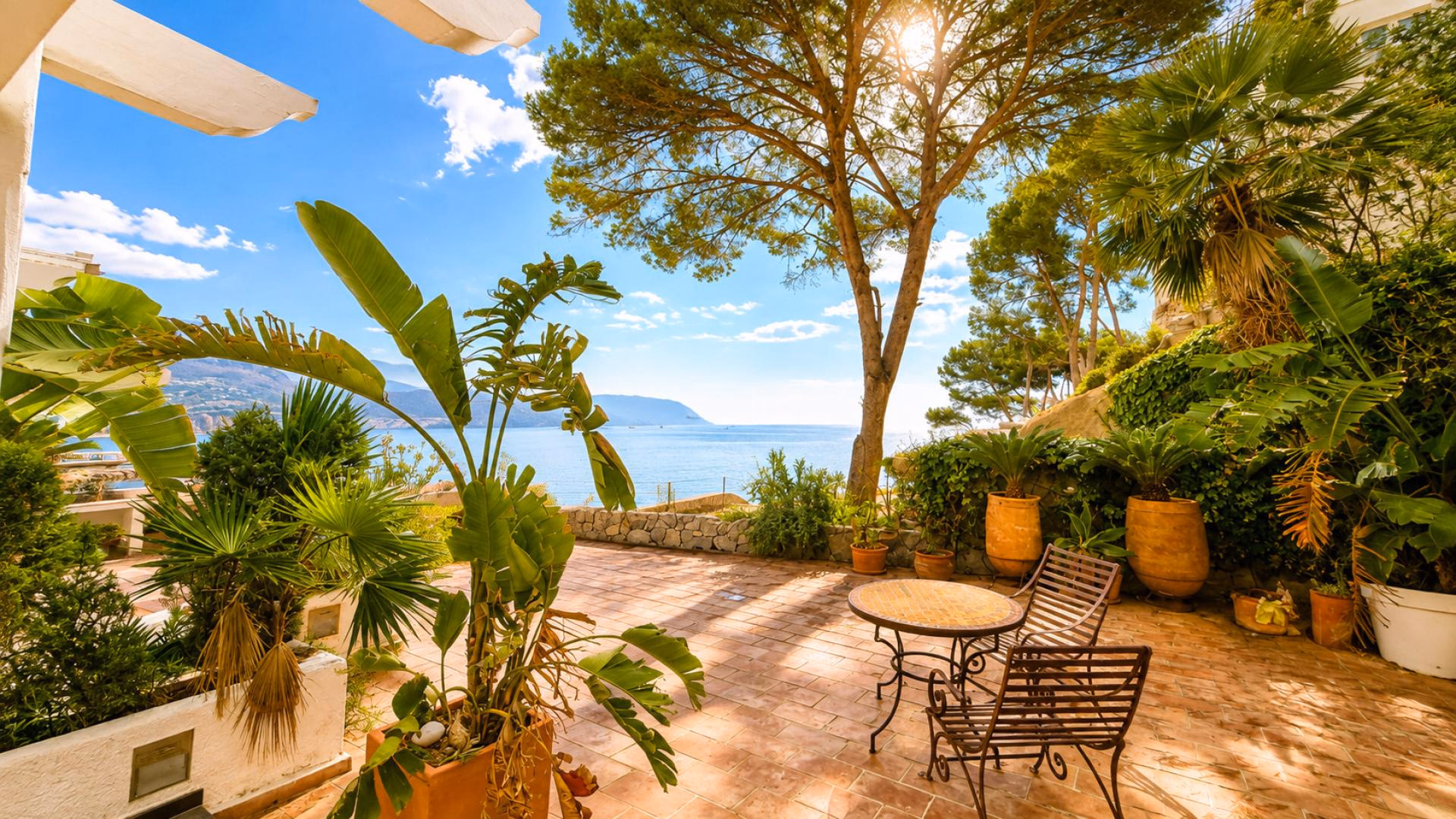 Terrasse mit Meerblick am Reihenhaus in La Olla mit Tisch, Stühlen und Pinien über der Bucht von Altea