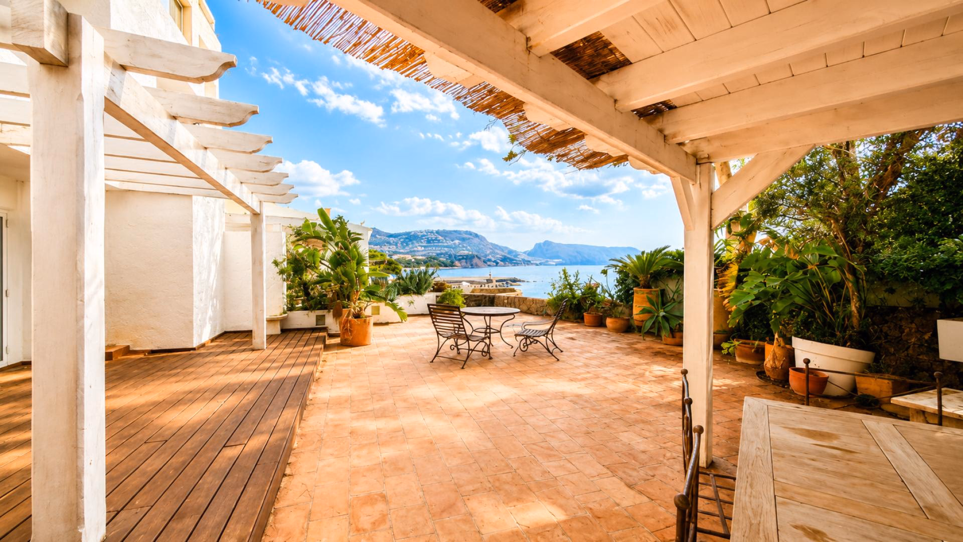 Überdachte Terrasse mit Holzpergola und Blick aufs Meer