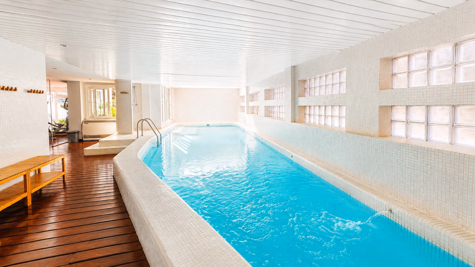 Beheiztes Hallenbad der Anlage mit Holzdeck