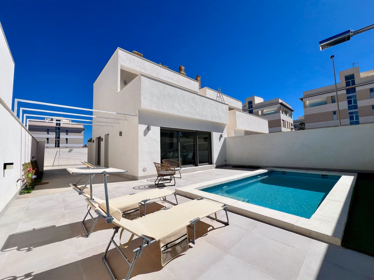 Villa exterior with private pool, sun loungers and roof terrace railings