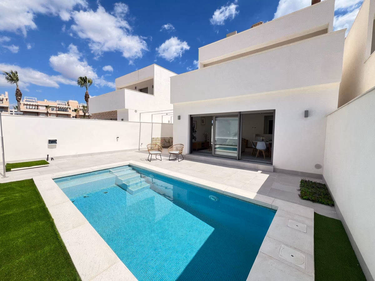 White detached villa with private pool and lawn under a blue sky, Orihuela Costa