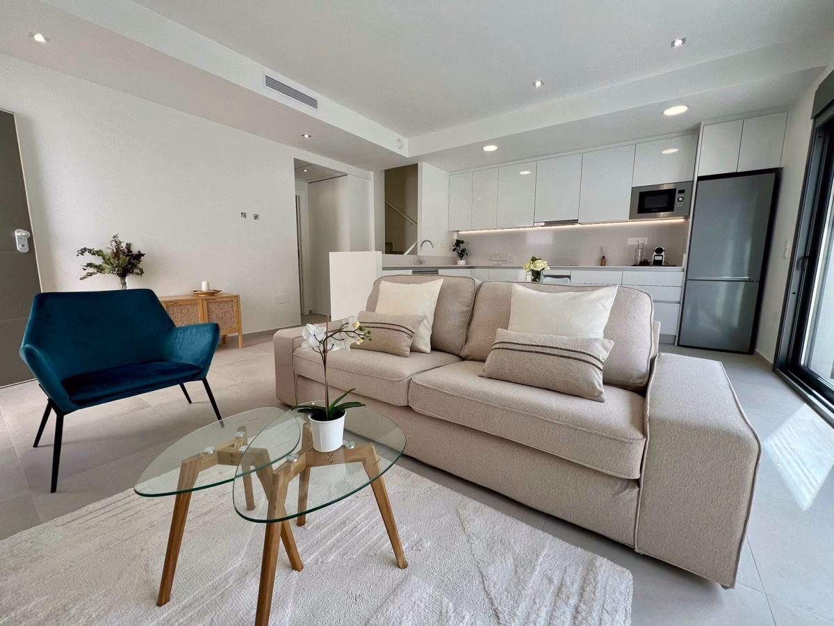 Lounge with sofa and the kitchen behind