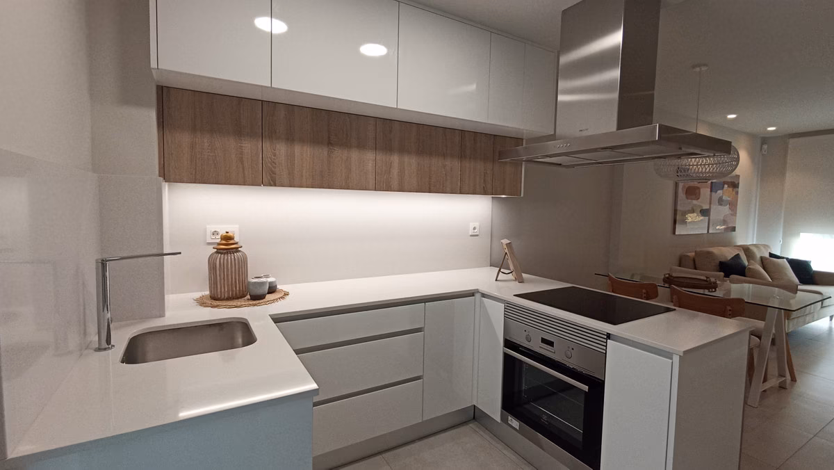 L-shaped kitchen with white units and an induction hob