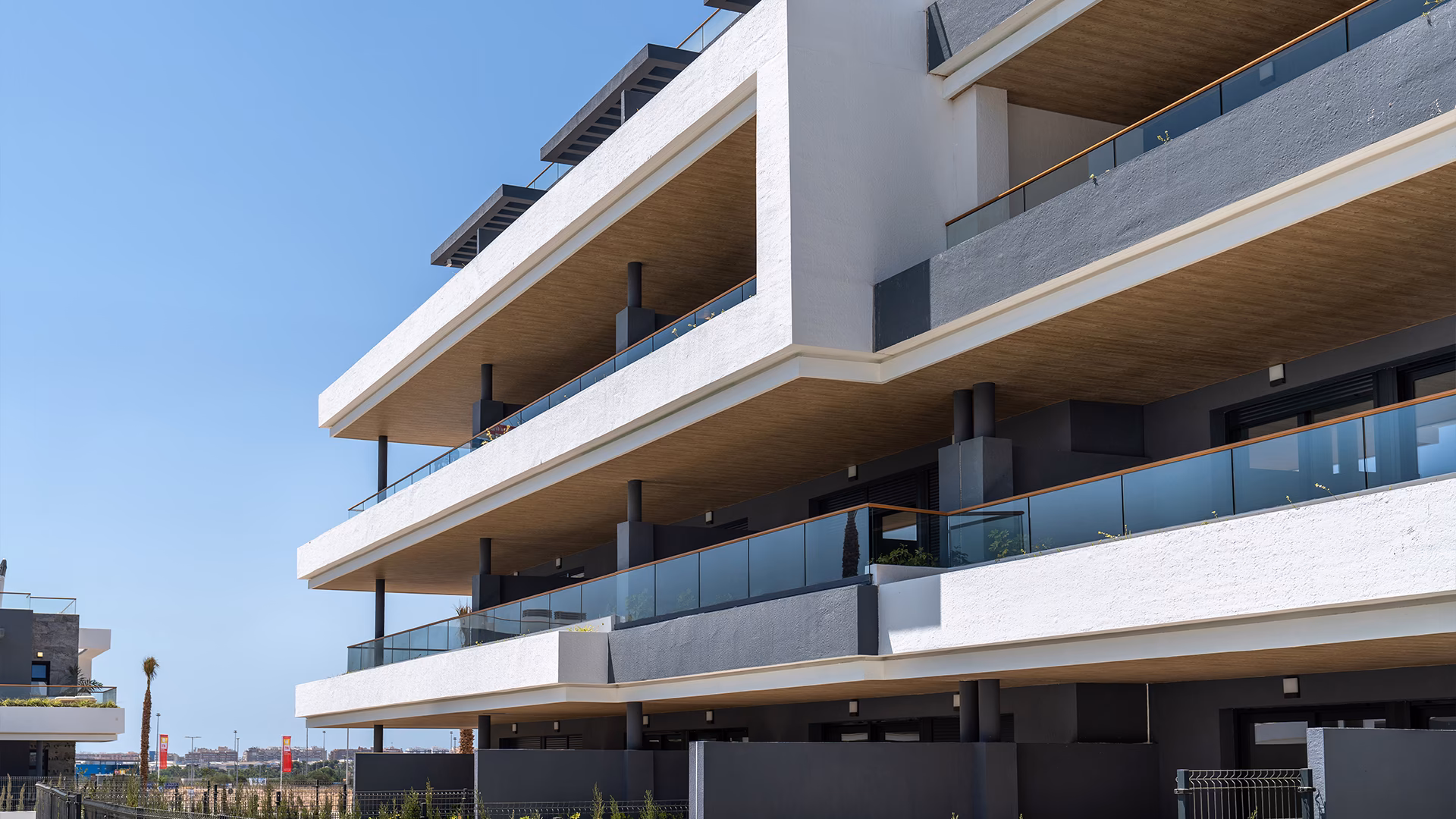 Apartmentfassade mit glasgeländerten Balkonen