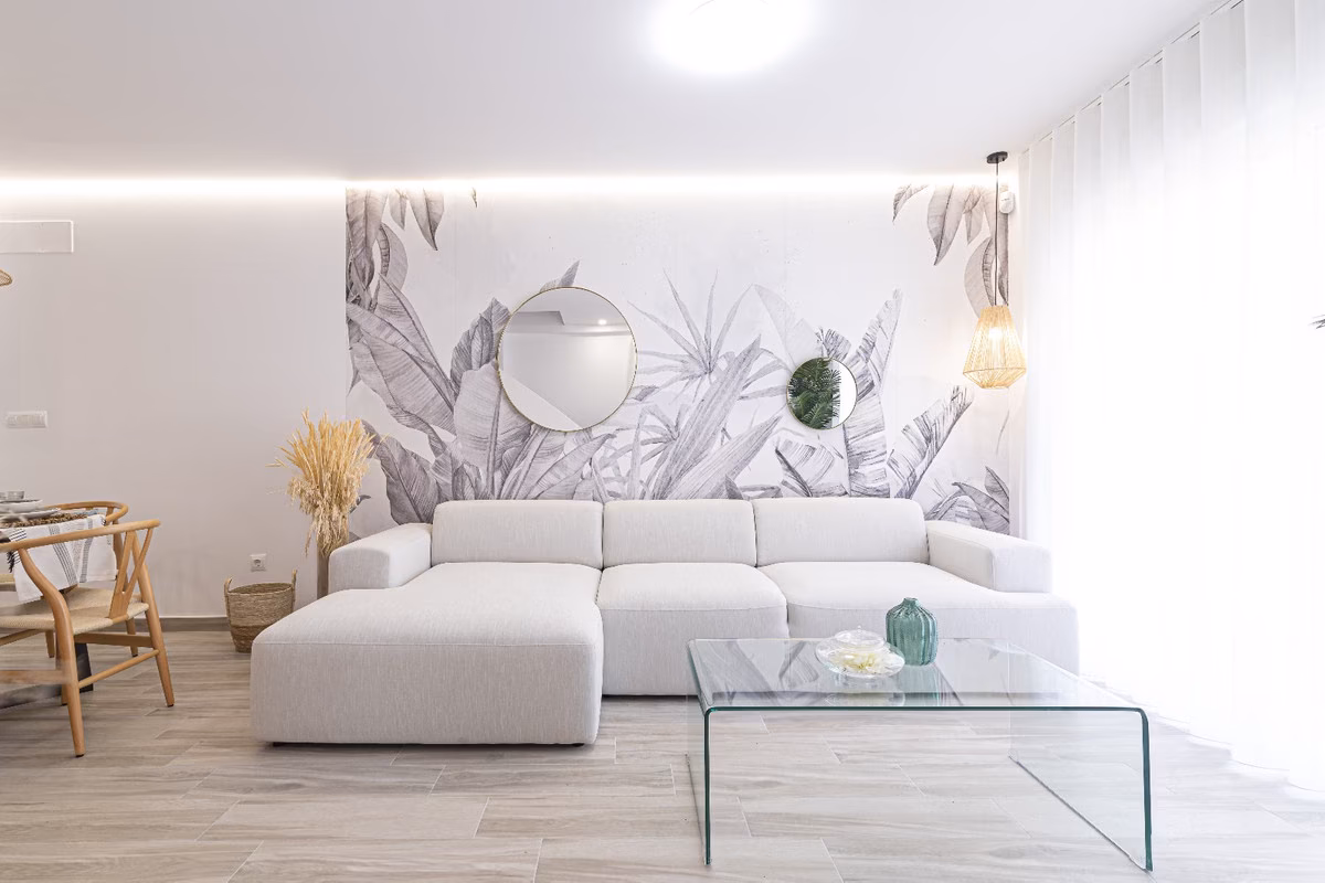 Wohnzimmer mit Ecksofa und botanischer Tapete
