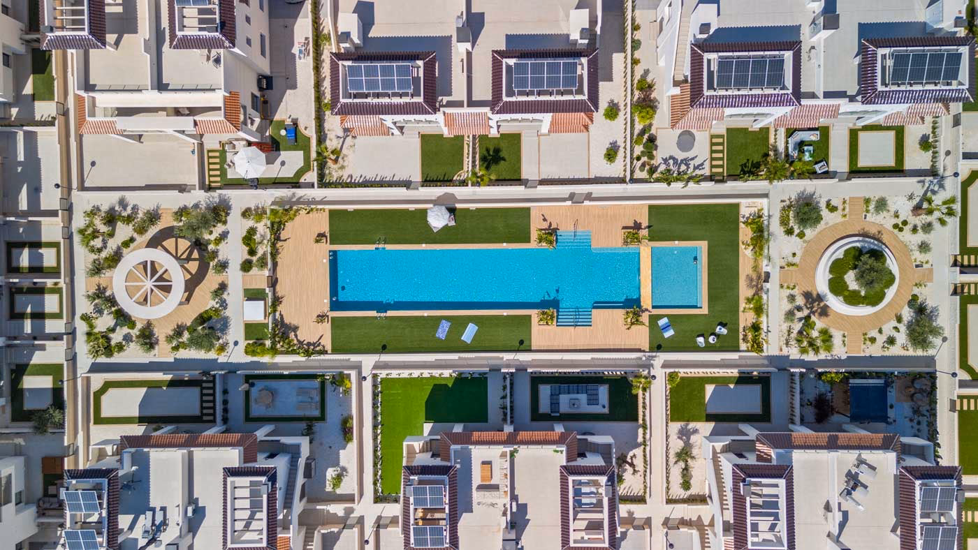 Vue aérienne : piscine commune et cours paysagées entre les immeubles