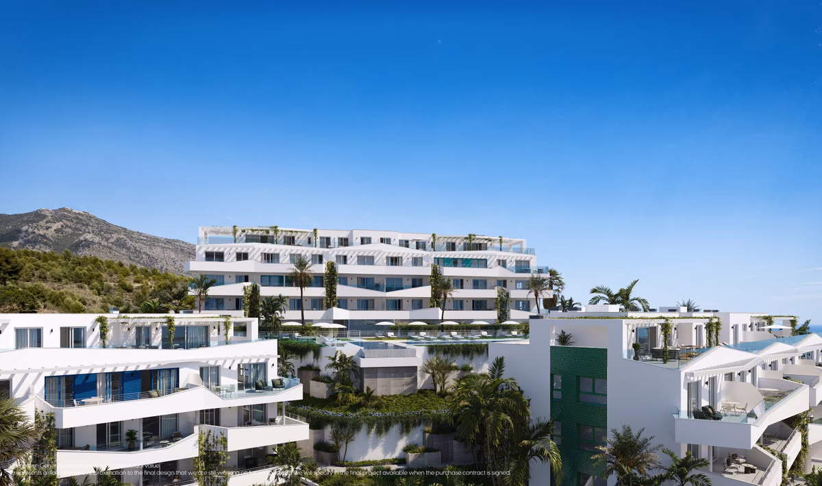 Terraced white buildings on the hillside with mountains behind