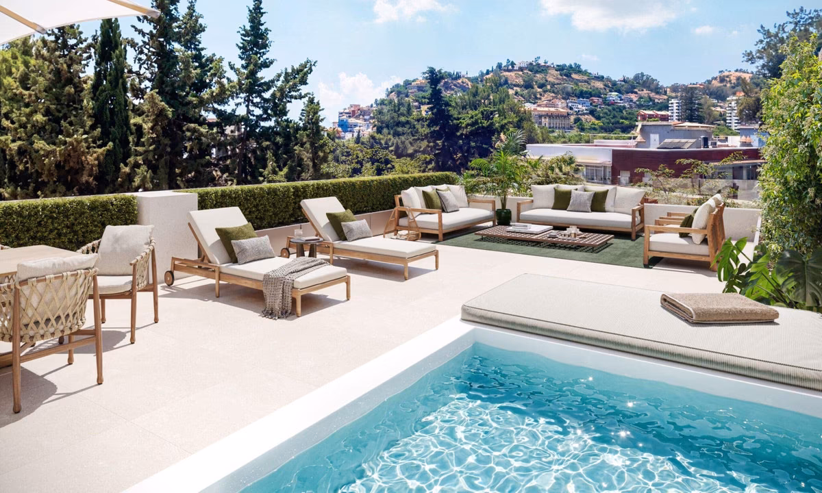 Sonnenterrasse mit Pool und Liegen vor bewaldeten Hügeln, El Limonar, Málaga