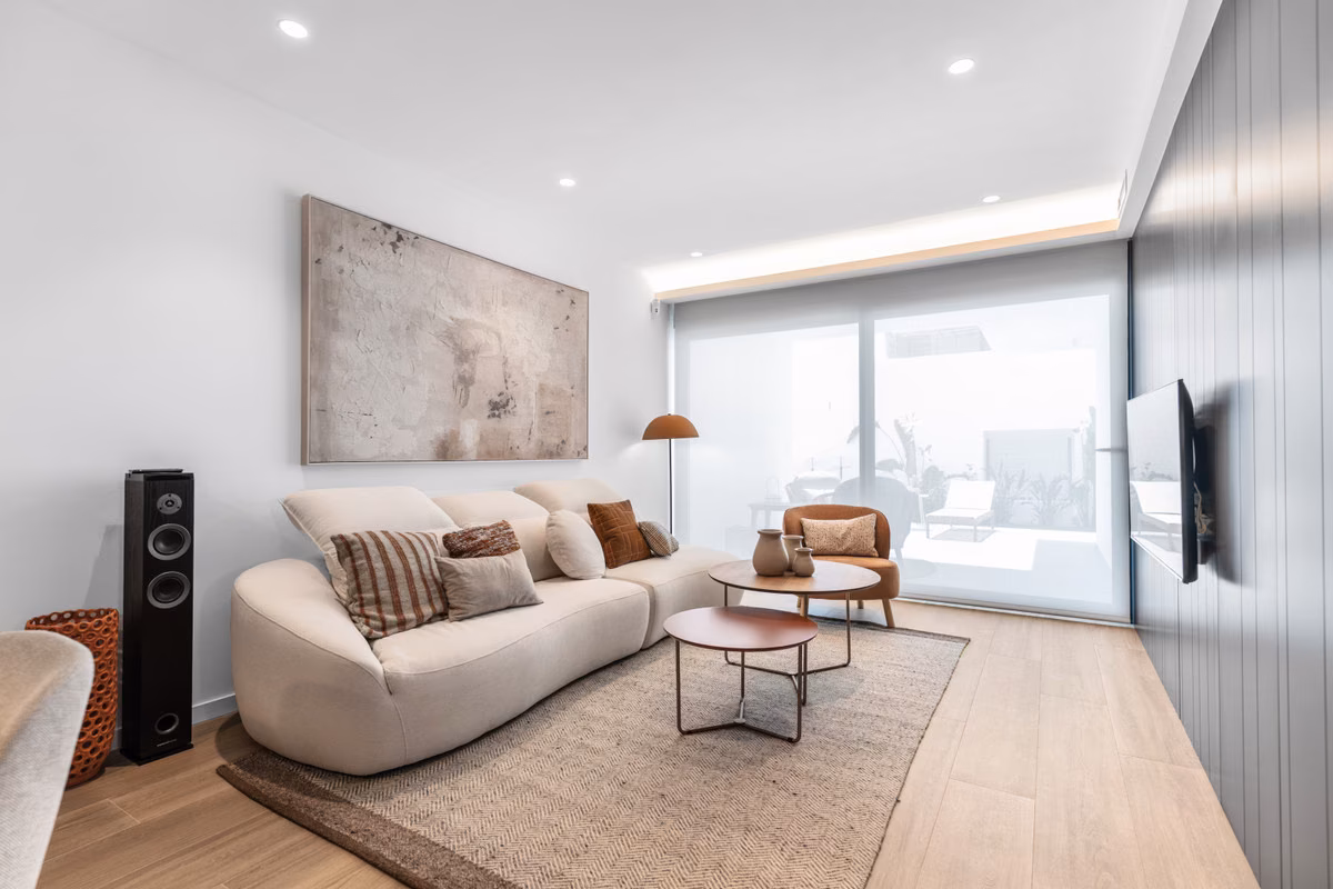 Wohnzimmer mit geschwungenem Sofa und raumhohem Fenster