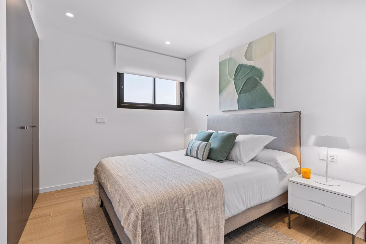Schlafzimmer mit grauem Kopfteil und grünen Kissen