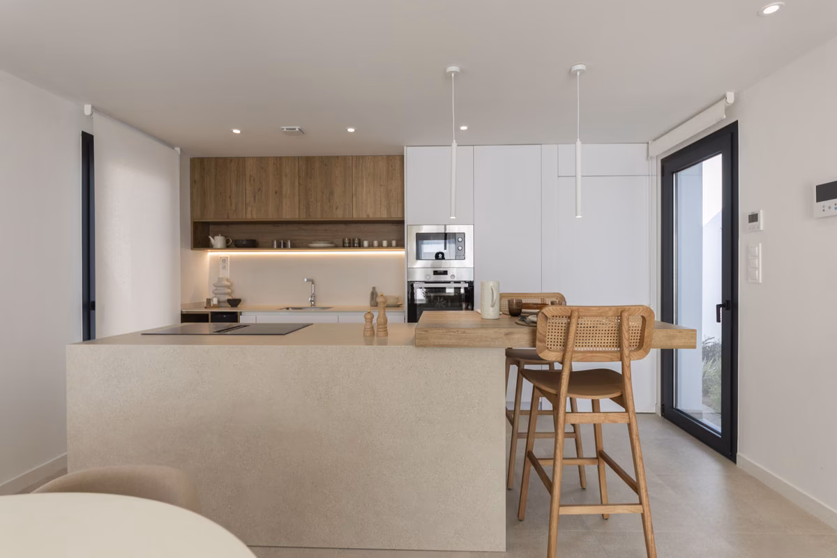 Kitchen with light island and bar stools in a Montemar villa