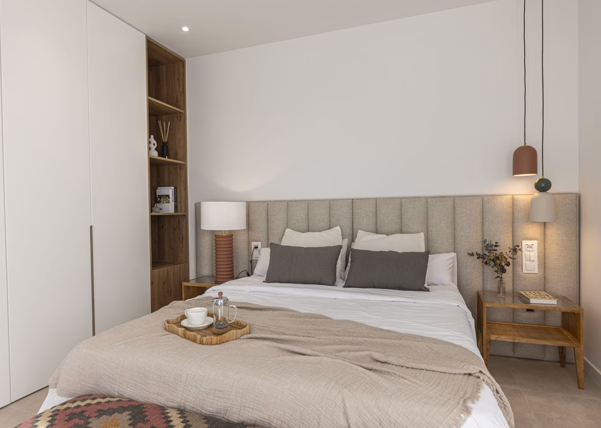 Bedroom with upholstered headboard and bedside lamp in a Montemar villa