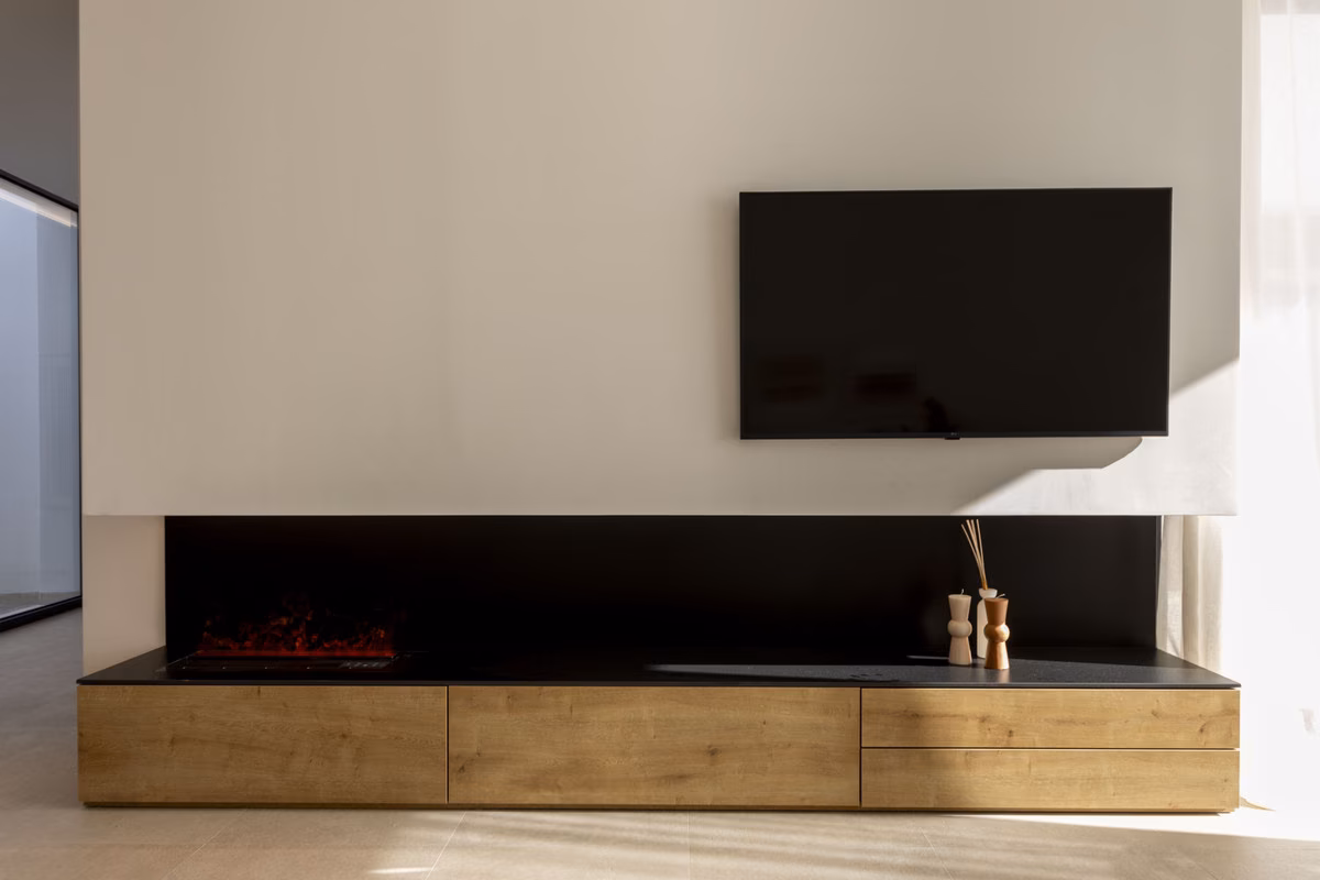 Linear fireplace below a TV wall in a Montemar villa