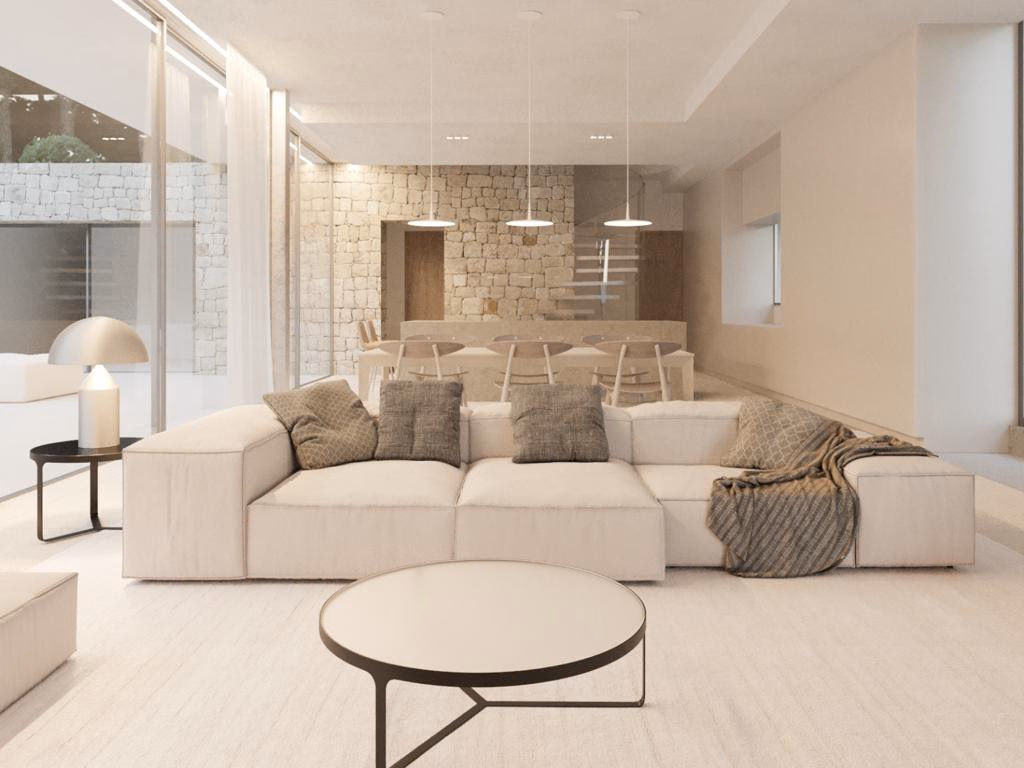 Lounge with a large sofa, a round coffee table and a stone feature wall