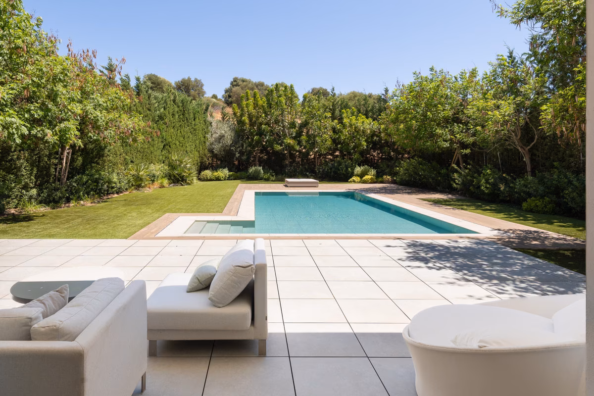Pool terrace with loungers beside the lawn