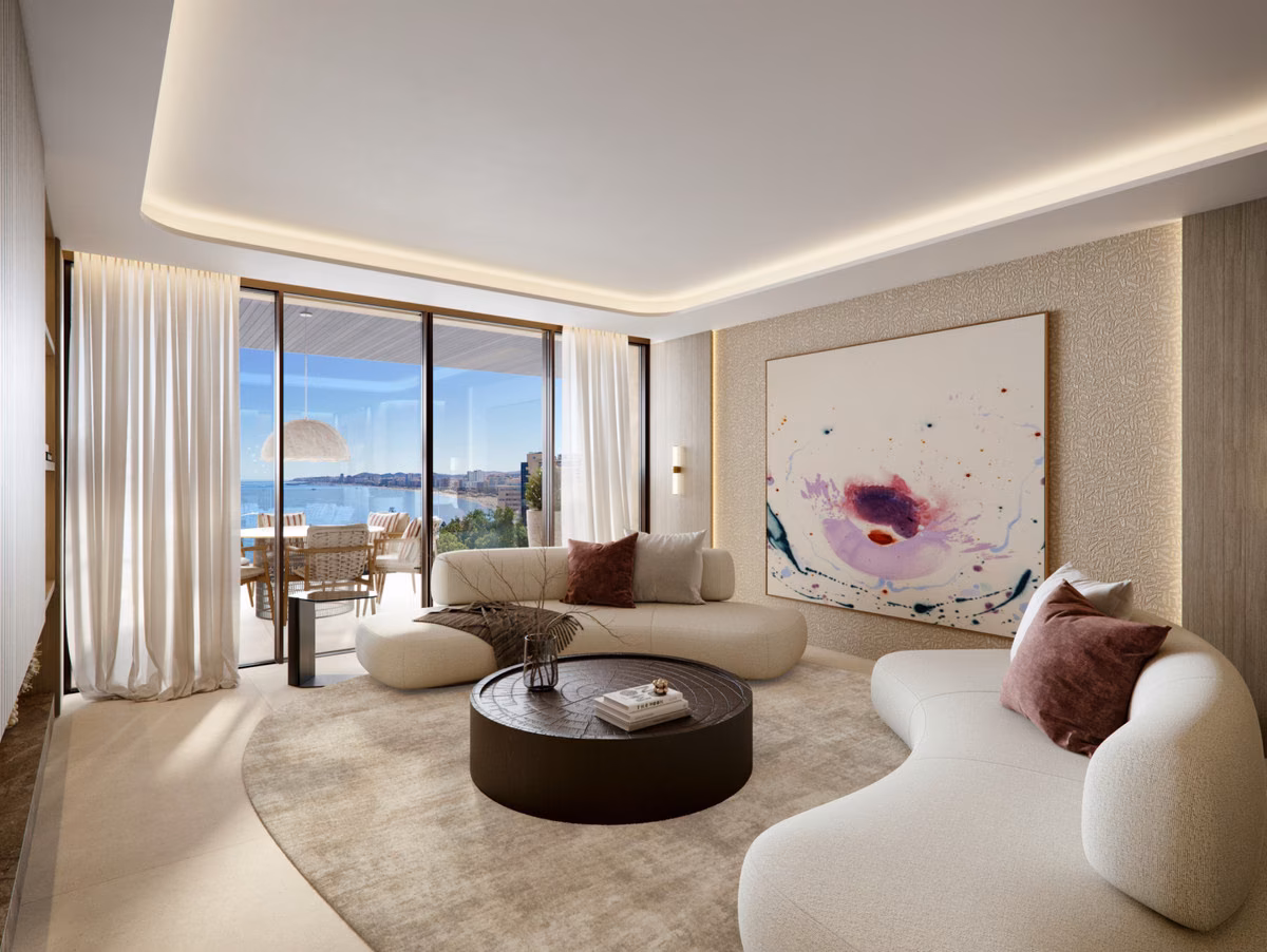 Wohnzimmer mit geschwungenem Sofa und Meerblick durchs Glas