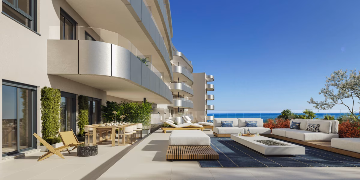 Möblierte Terrasse mit Sofas und Essbereich bei One Oak, im Hintergrund das Meer
