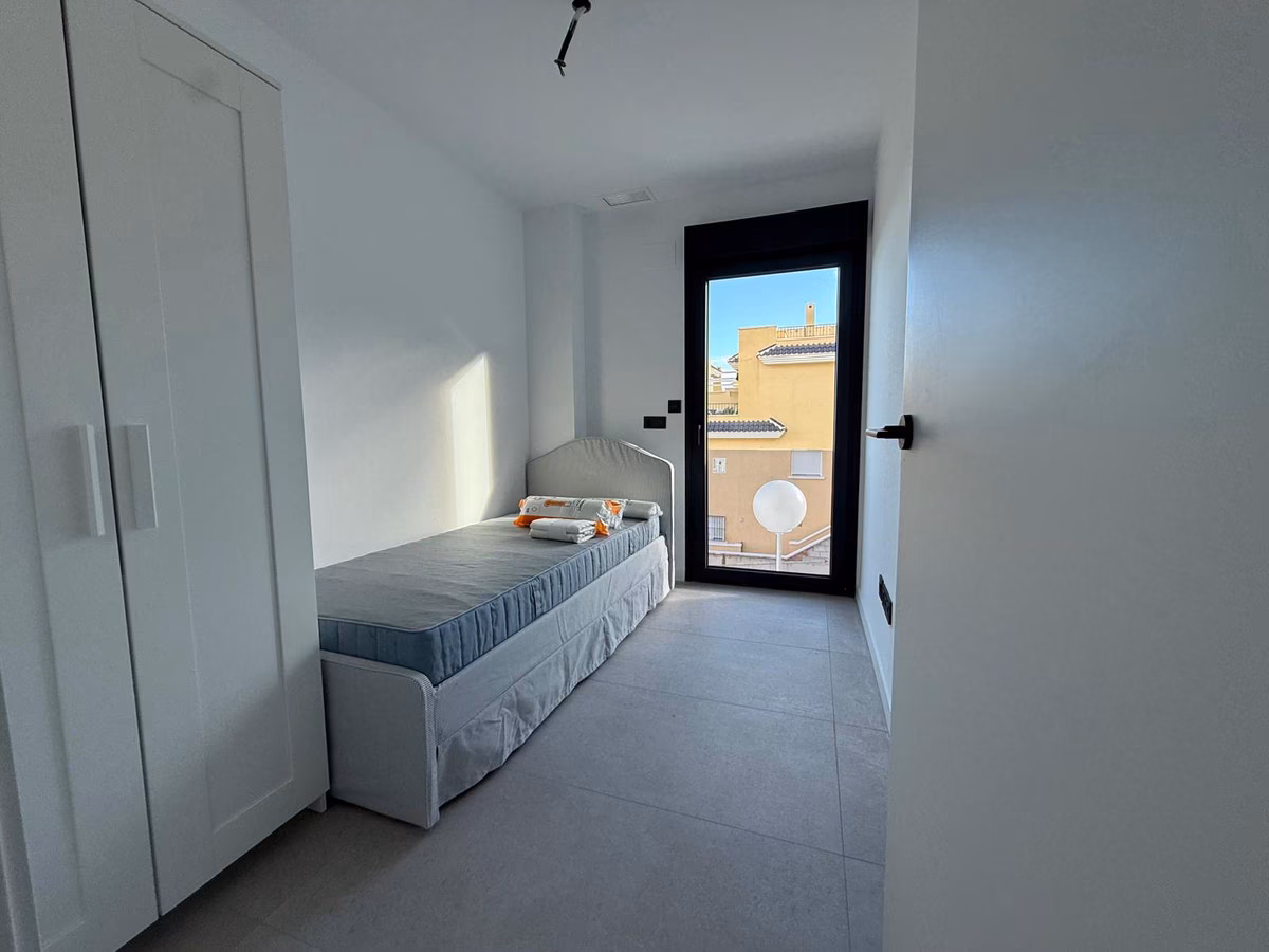 Schlafzimmer mit Einzelbett und Glastür zur Terrasse in einer Wohnung von Panoramar