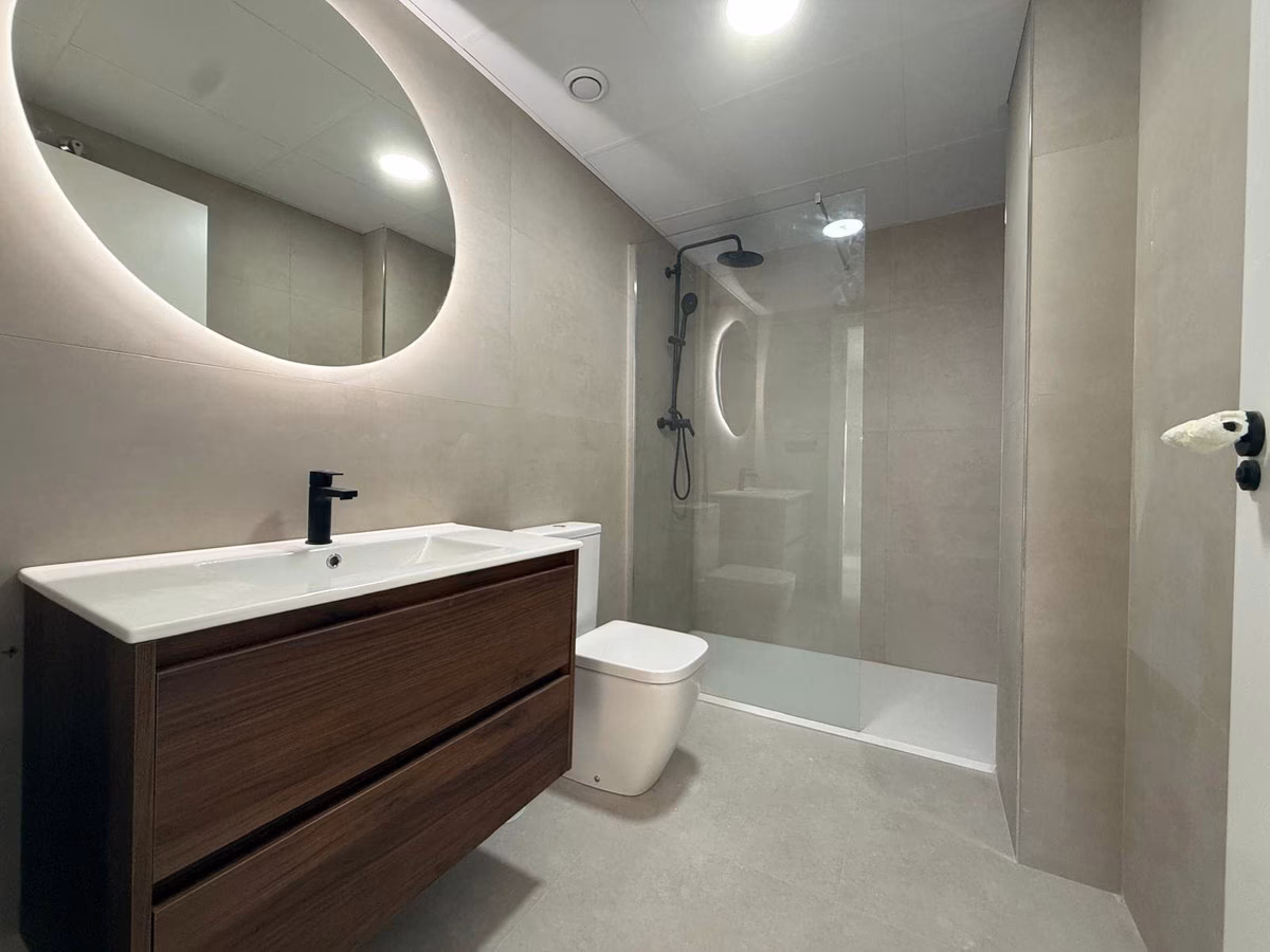 Bad mit bodengleicher Dusche und Waschtisch in einer Wohnung von Panoramar