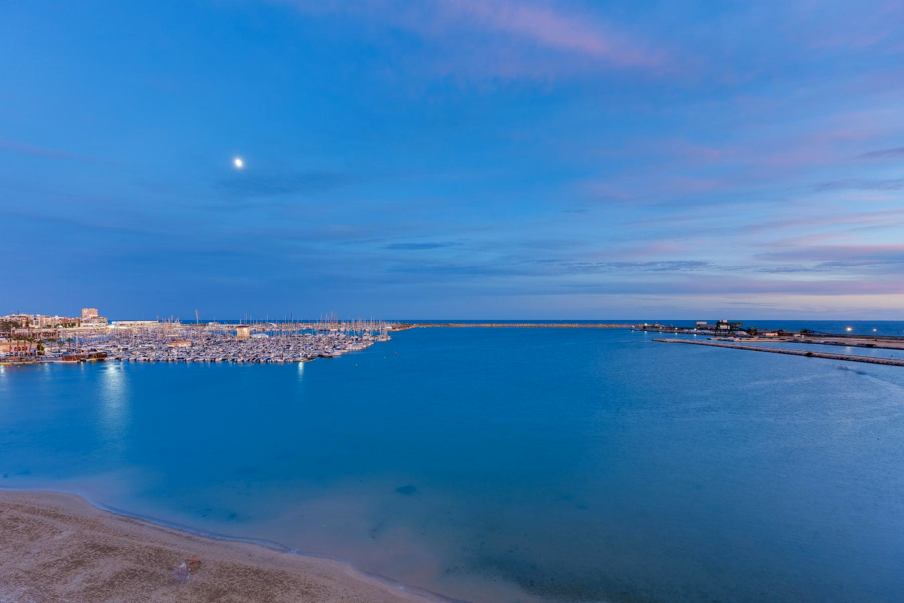 View from the fifth floor over Playa del Acequión, the port of Torrevieja and the bay at dusk