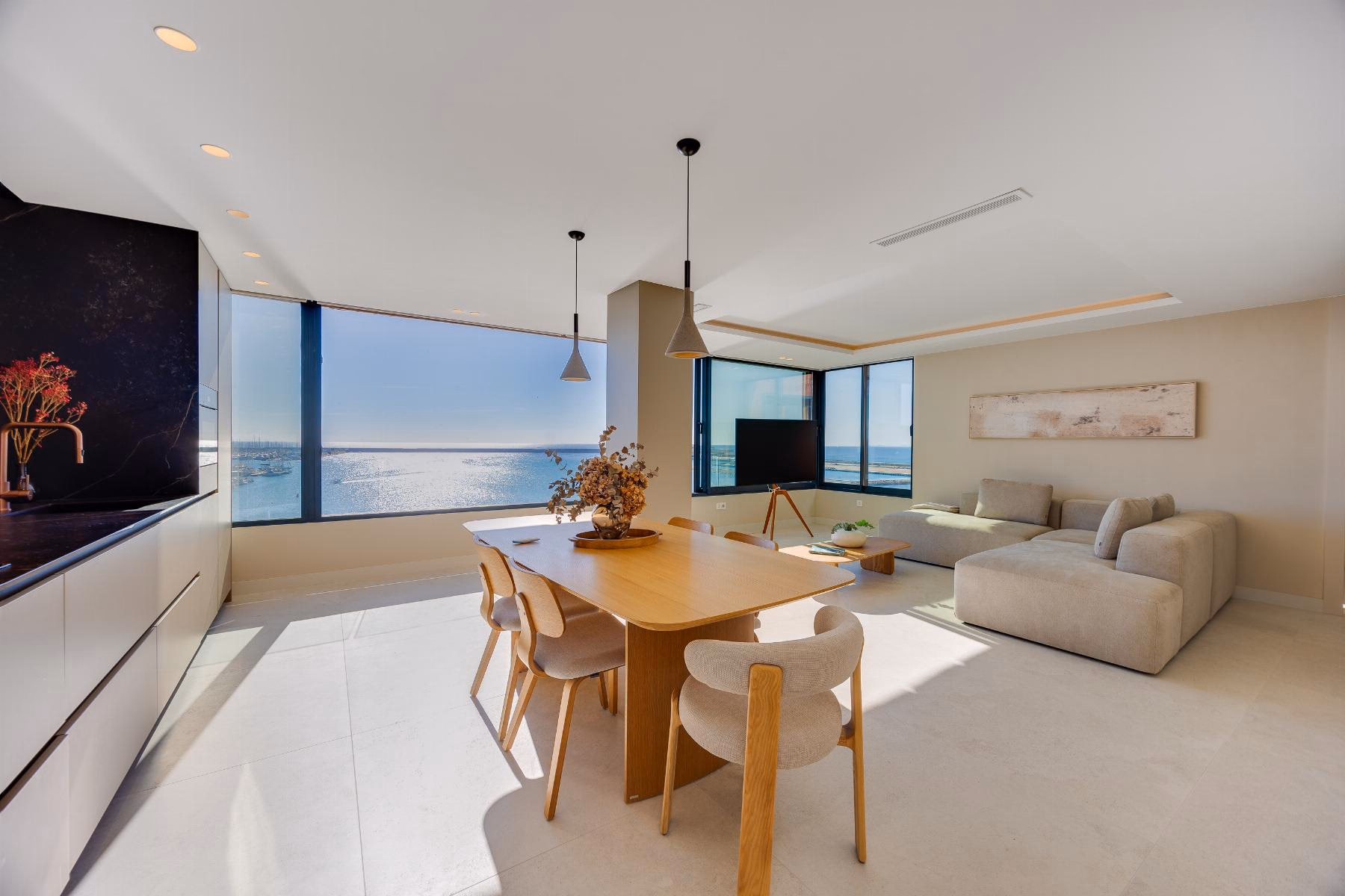 Open-plan room with dining table, sofa and panoramic windows