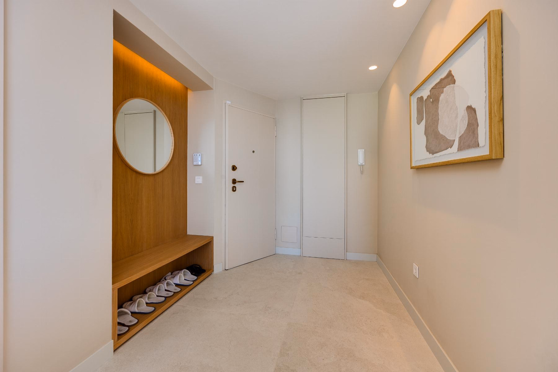 Entrance hall with a bench, round mirror and built-in wardrobe