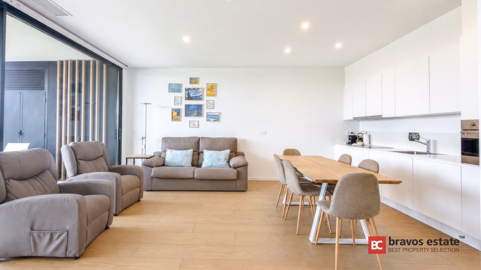 Część dzienna z białą kuchnią w zabudowie w apartamencie Pure Sea Residence