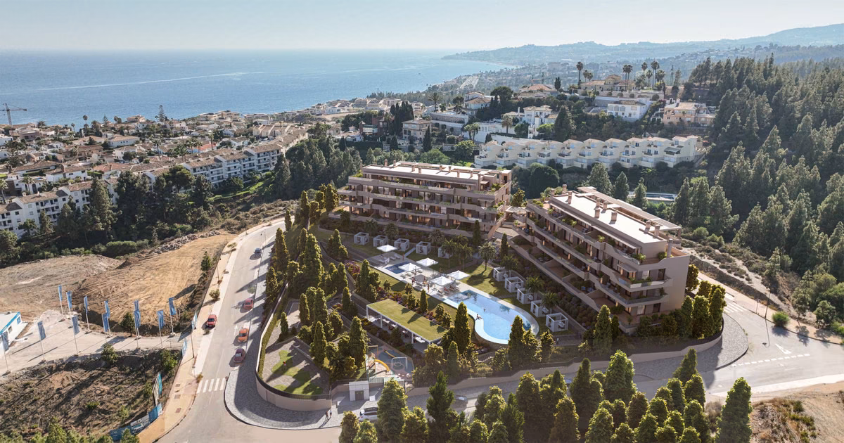 Vista aérea de los dos edificios escalonados sobre la costa con el jardín y la piscina en medio