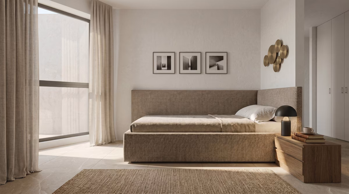 Bedroom with upholstered headboard and framed prints